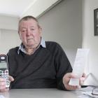 Brian Cherry with his phone and some of the Paysafecard vouchers the scammer told him to buy....