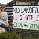 Olivia Smith beside a sign on a fence in Oxford opposing the proposal to establish an industrial...