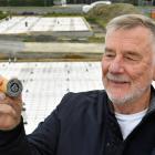 Roger Fewtrell displays the stamp of his new housing charity in front of two houses he is...