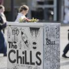 A floral posy placed on a traffic-control box featuring a tribute to Dunedin band The Chills in...