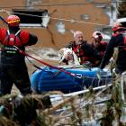 A man holds a dog as he is aided by rescuers on a flooded street in Jesenik,&nbsp;Czech&nbsp...