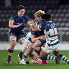 Finn Hurley holds on tight to the ball, with Will Stodart on the left, in Otago's NPC match...