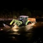 A tractor, with six occupants, was stuck in the middle of a surging river on the West Coast at...