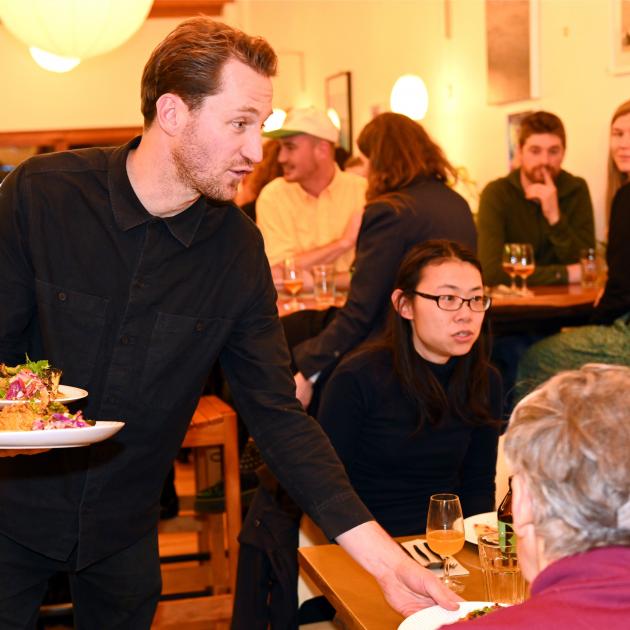 Everybody Eats founder Nick Loosley serves dinner at Kind Company on Friday night. PHOTOS: LINDA...