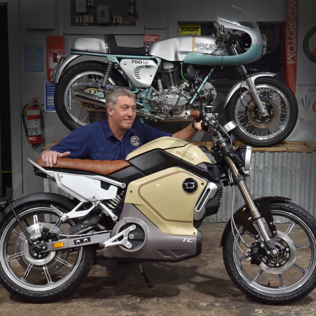 Motorcycle Replacements co-owner Rick Jamieson looks over a 2019 Super Soco TC electric moped....