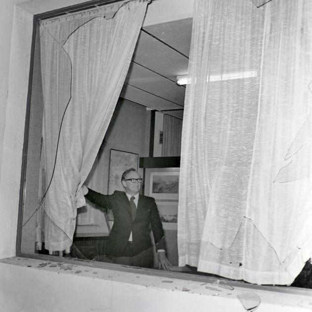 Bill Mcindoe pulls back the curtain to survey the smashed plate glass window of his firm’s...