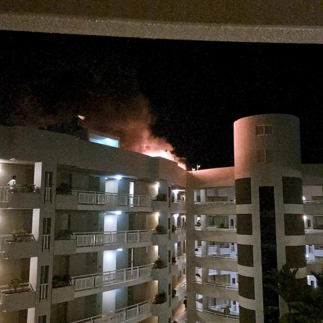 A fire burns at the Double Tree Hotel after a helicopter crashed into the roof in Cairns,...