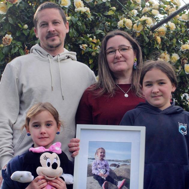 Holding a photo of Tessa, Tyler Titchmarsh and Julie Little and their two other daughters, Gracie...