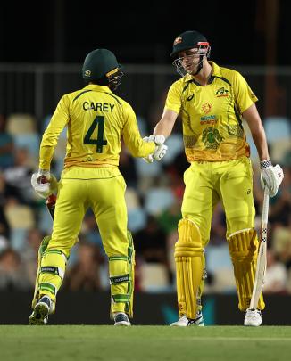 Australia's Cameron Green celebrates with Alex Carey after scoring a half century against New...