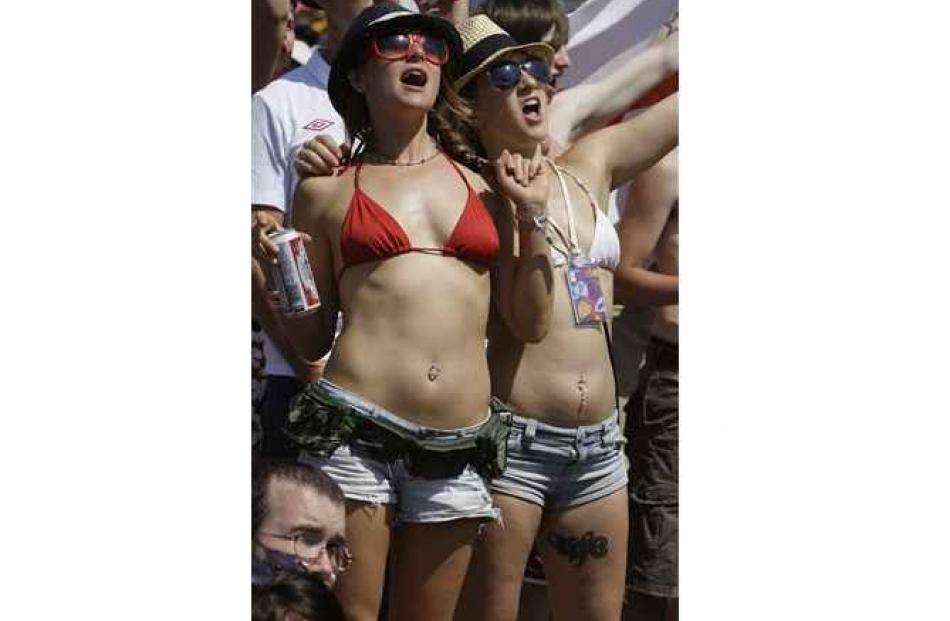 Football fans cheer as they watch the action on two big screens provided for the World Cup soccer...