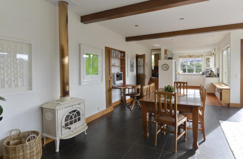 The dining area with the kitchen beyond. A small TV lounge is hidden from view up a few steps to...