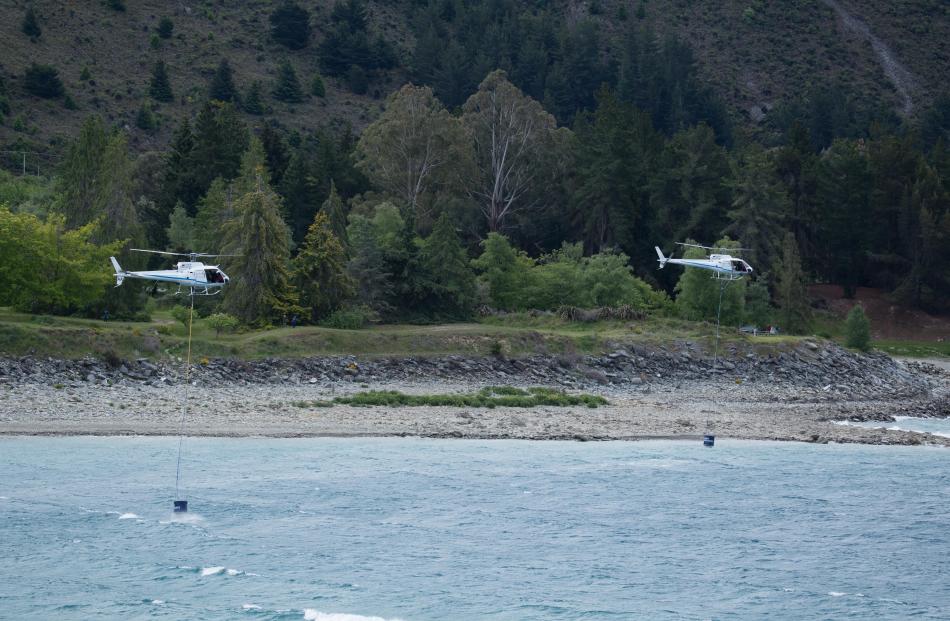 Helicopters fill up monsoon buckets to fight the blaze at Lake Hawea. Photo: Andy Cole