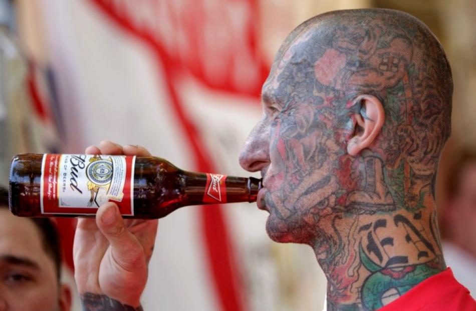 An England fan has a drink in Donetsk, before his team's first match, against France.