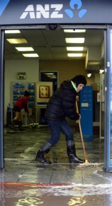 Sandra Wilson sweeps water out of the ANZ bank.