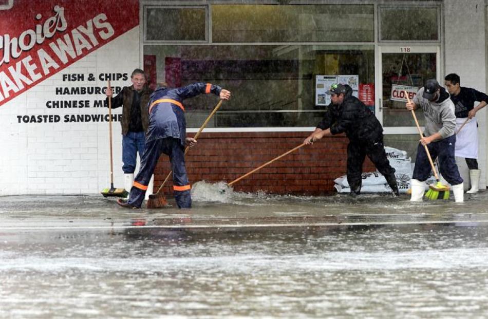 Trying to keep the water away from Mosgiel businesses are (from left) Larry Greenall, Jeff Wilson...