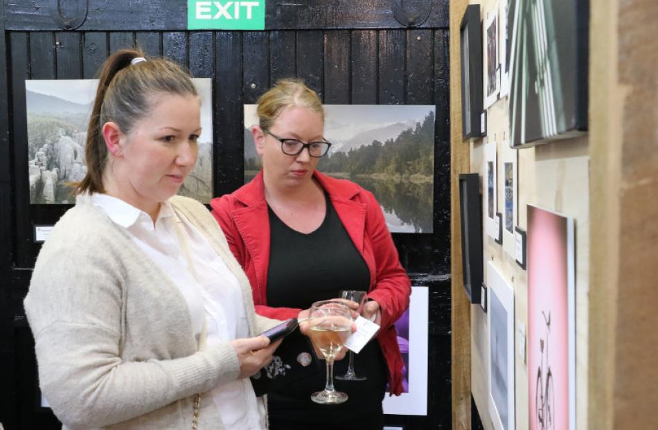 Lovely photos ...Anna Labedz (left) and Em Skipper look over the prints on offer.