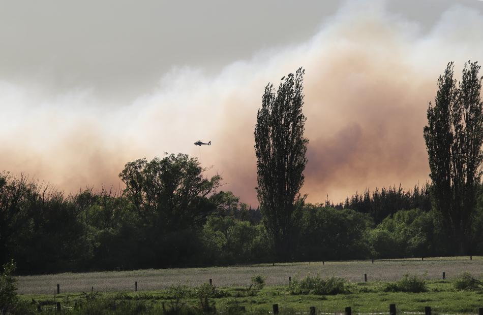 All hands on deck . . . Helicopters with monsoon buckets are fighting the large fire in the...