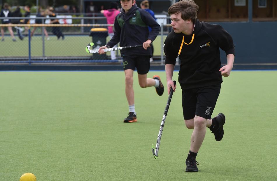 Dekin Jones (15), of Logan Park High School, chases down the hockey ball.