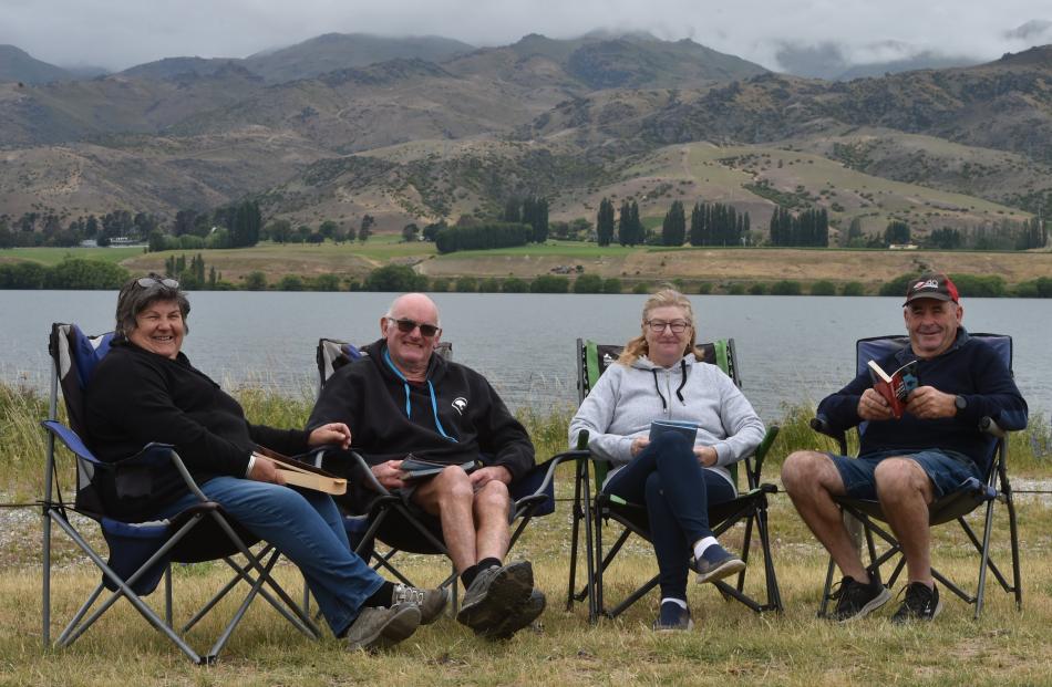 Enjoying reading a book at the Lowburn camping grounds on the shores of Lake Dunstan are (from...