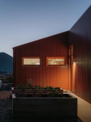 Planter boxes at the back of the house contain vegetables.