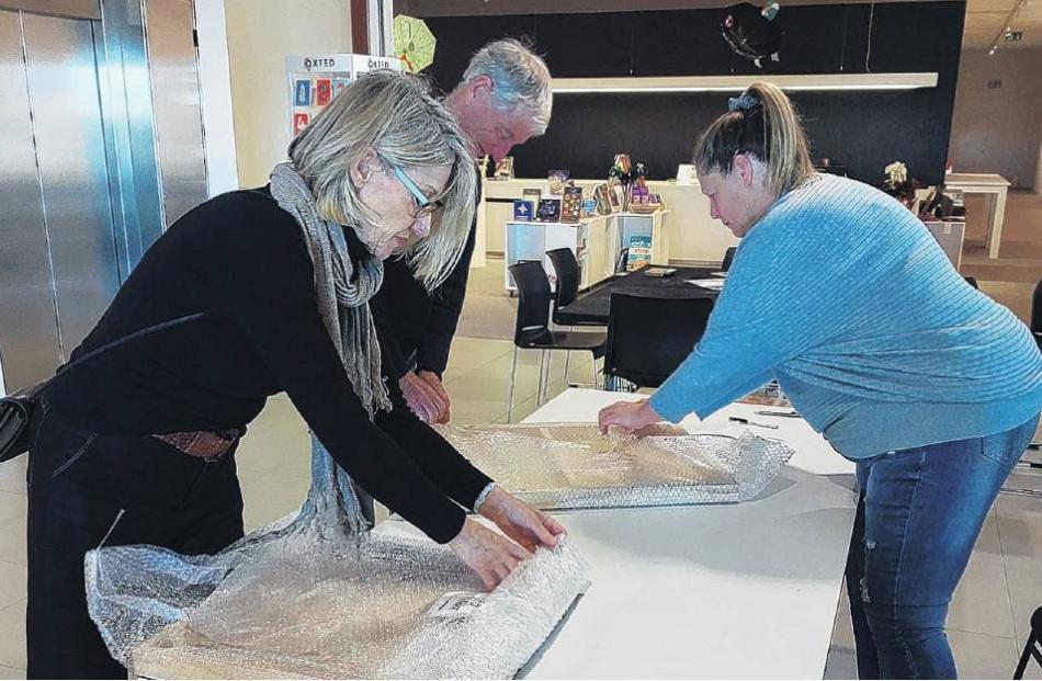 Committee member Lynda Scott (right) checks in some of the new work. PHOTO: SUPPLIED