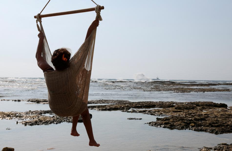 A woman rests in a hammock by the beach in Batroun, Lebanon.