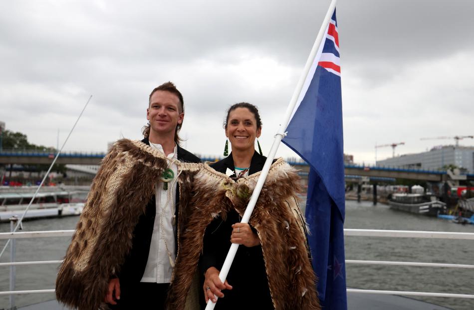 New Zealand flagbearers Aaron Gate and Jo Aleh do the honours on board their nation’s boat.