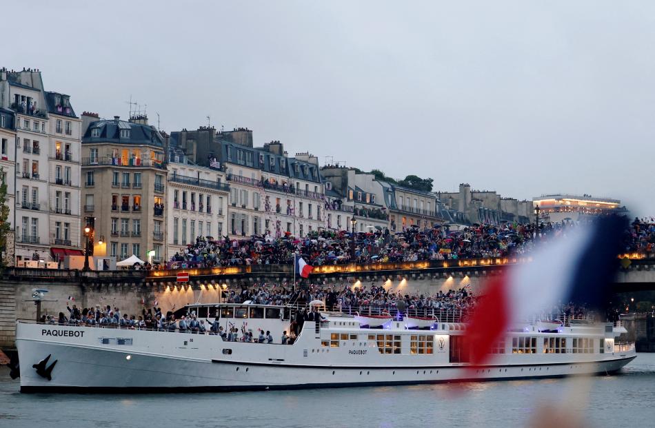 The French delegation’s boat floats past crowds lining the Seine.