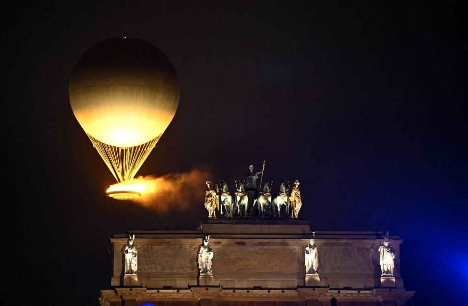 The balloon carrying the Olympic cauldron floats above the ceremony.