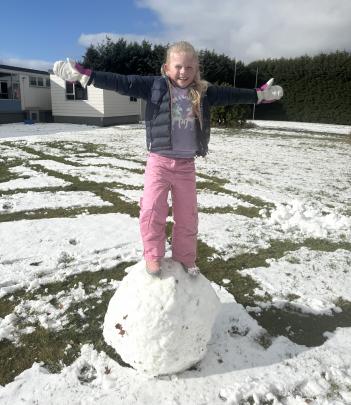 Florence Harris (7), stands on the snowball she made at school yesterday.