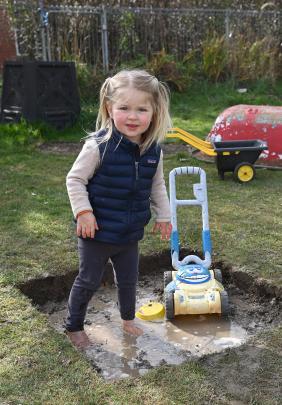 Paloma McDowell, 2, attempts to mow a mud pool, without success.