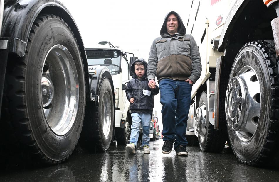 Mick Ross leads his son, Mack, 6, to one of the rigs.