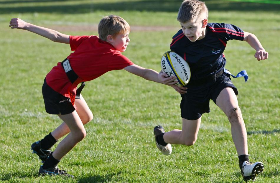 Hayden Joyce, 9, of Palmerston Primary School tries to catch Mason Jenkins, 11, of Grant's Braes...