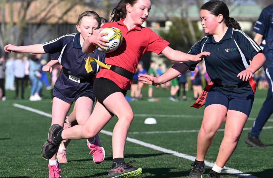 Ria Heckler, 9, of Palmerston Primary School, looks for a way past Elmgrove School defenders...