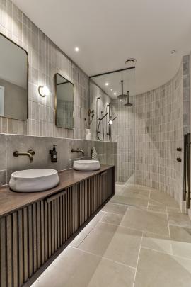 The ensuite has a custom oak vanity, limestone tiles and a curved shower wall.