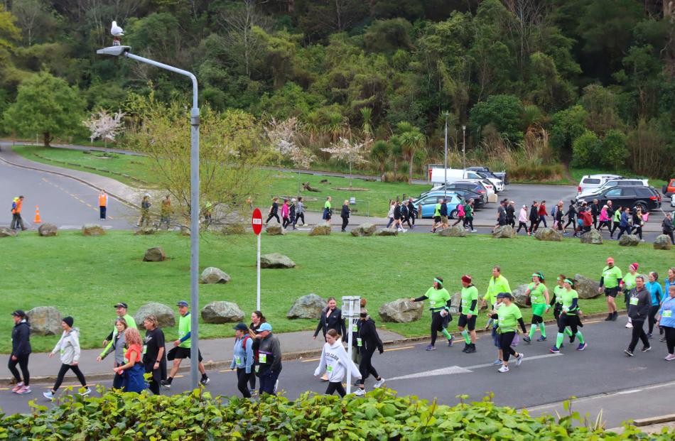 Participants traverse a loop in front of Logan Park High School at the start of the 10km walk ...