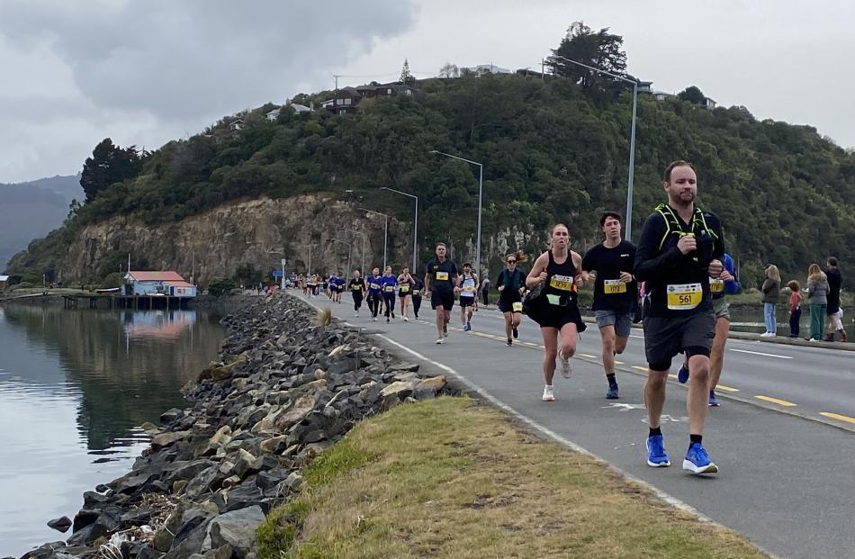 On track ... Tim Murphy (561) and fellow competitors run alongside a calm Dunedin Harbour during...