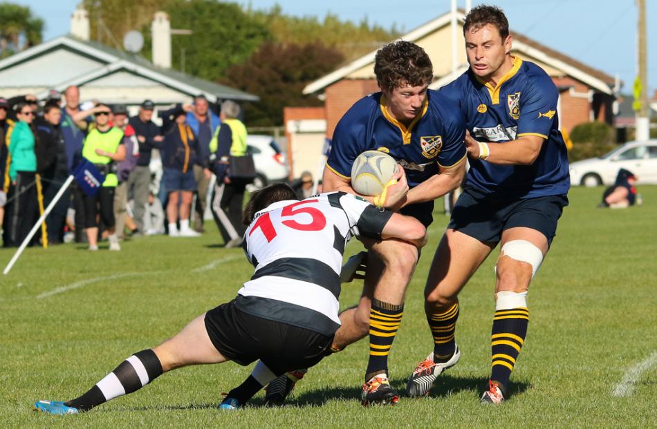 Dunedin wing Henry Scott is tackled by Southern fullback Bryce Hosie as team mate Rowan McKenzie...