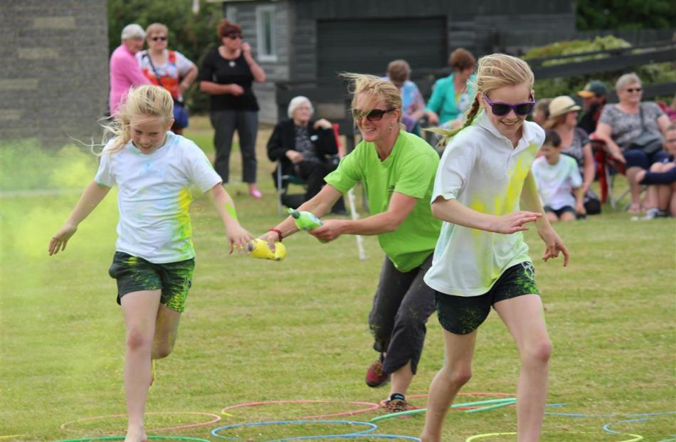 Bronte Williams (left)  and Magan Mitchell (both 10) try to escape the splashes of paint being...