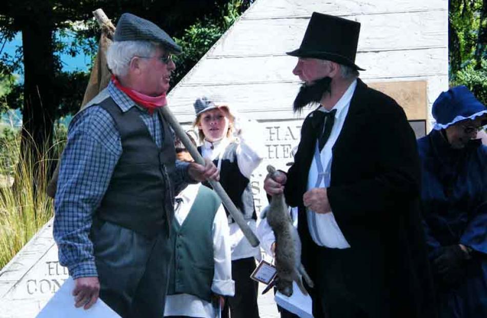 History buff Brian Bayley, costumed as a Gold Rush era trapper, handed a rabbit as a gift to...