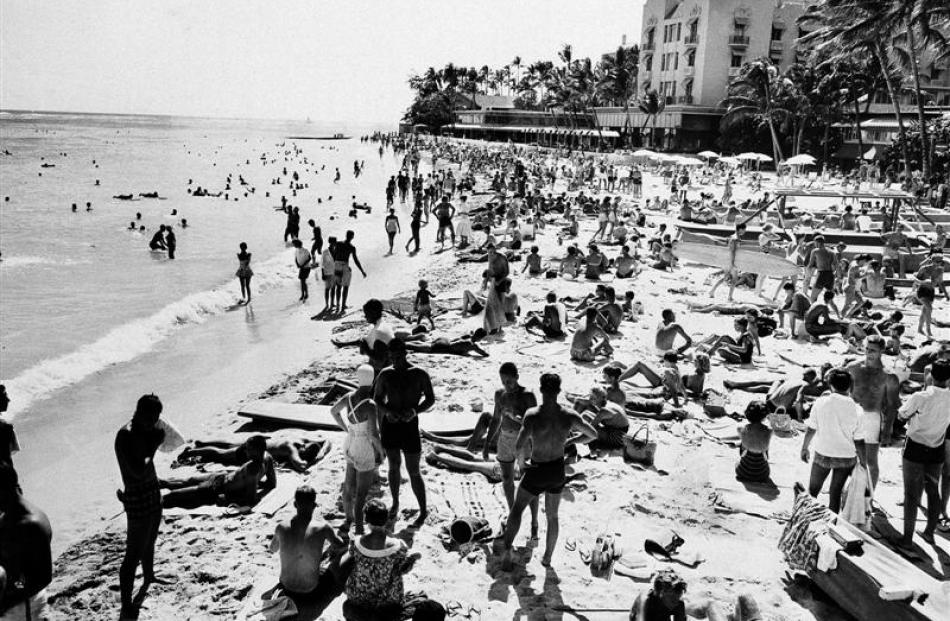 Vacationers and residents crowd Honolulu's Waikiki Beach near the Royal Hawaiian Hotel on Oahu in...