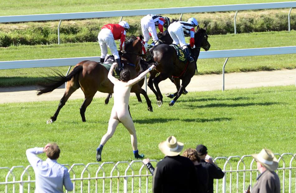 A streaker follows the horses.