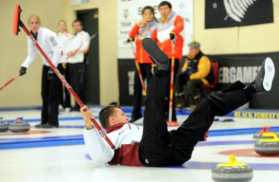 Ansis Regza slips on the ice during the Winter Games curling at the Maniototo International...