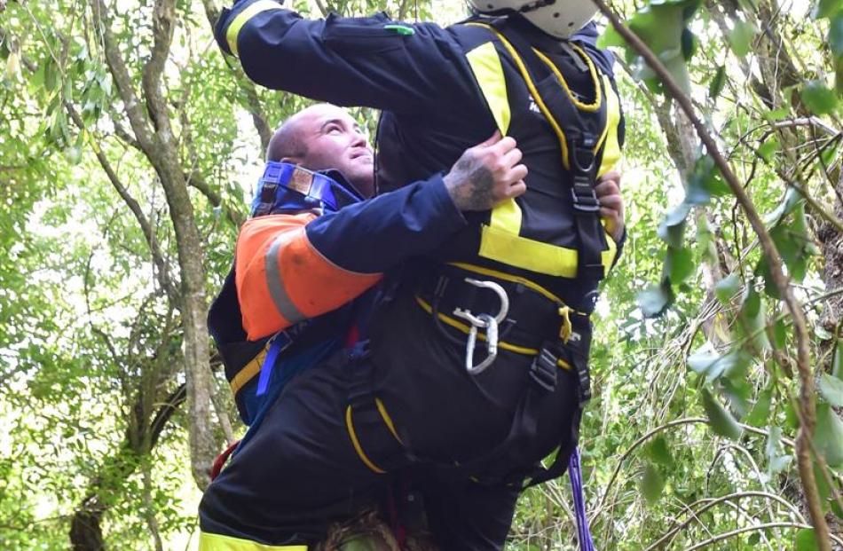 Luke Direen (left) is winched out of bush by the Otago Regional Rescue Helicopter crew. Photo by...