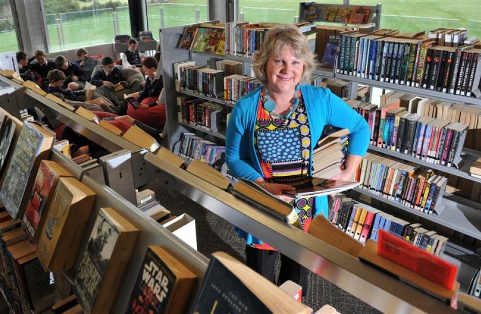 John McGlashan College library manager Pam Garry continues to stack books after winning the...