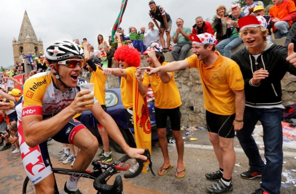 Lotto-Belisol rider Adam Hansen of Australia drinks a glass of beer as he climbs the Alpe d'Huez...