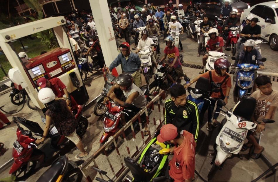 Motorists queue on their vehicles to buy petrol before a fuel price hike on Saturday by the...