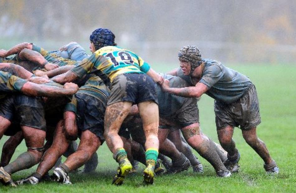 Green Island and University A players scrum at a muddy Miller Park.