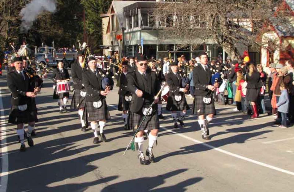 The Queenstown and Southern Lakes Highland Pipe Band leads the parade.