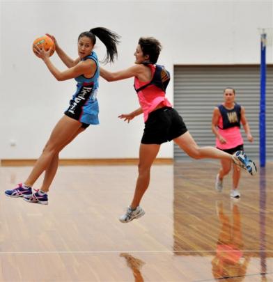 Steel wing attack Courtney Tairi takes a pass despite the attention of Legends defender Stephanie...